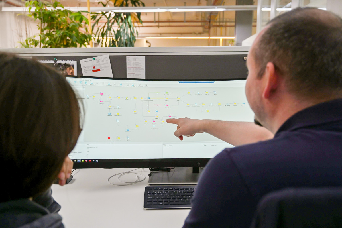 Personen zeigen auf Monitor