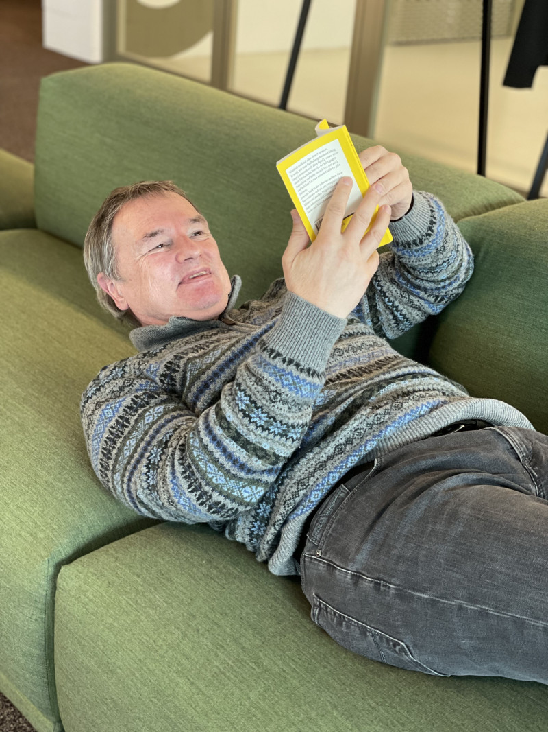 Liegender Mann liest Buch